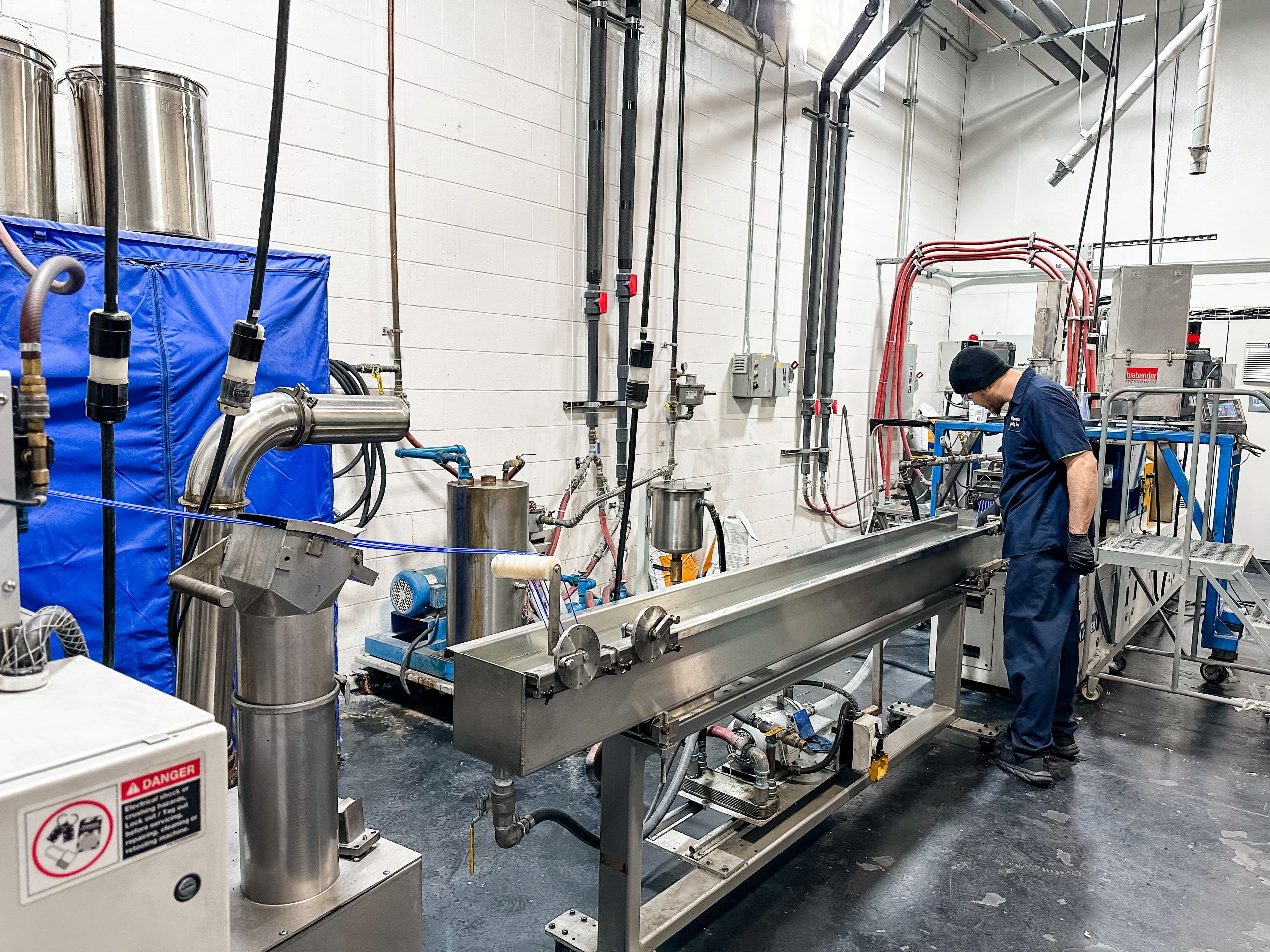 Peak Performance Custom Compounding Employee managing extrusion line